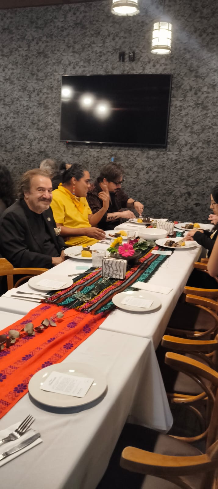 Mesa larga con textiles mexicanos coloridos en un evento de Judith Alessandra