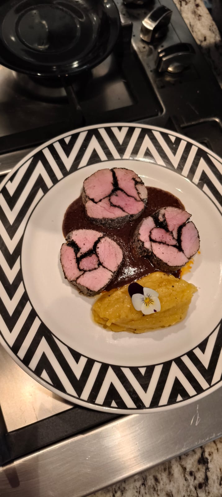 Lomo de cerdo con costra de especias y puré con flor pansy comestible